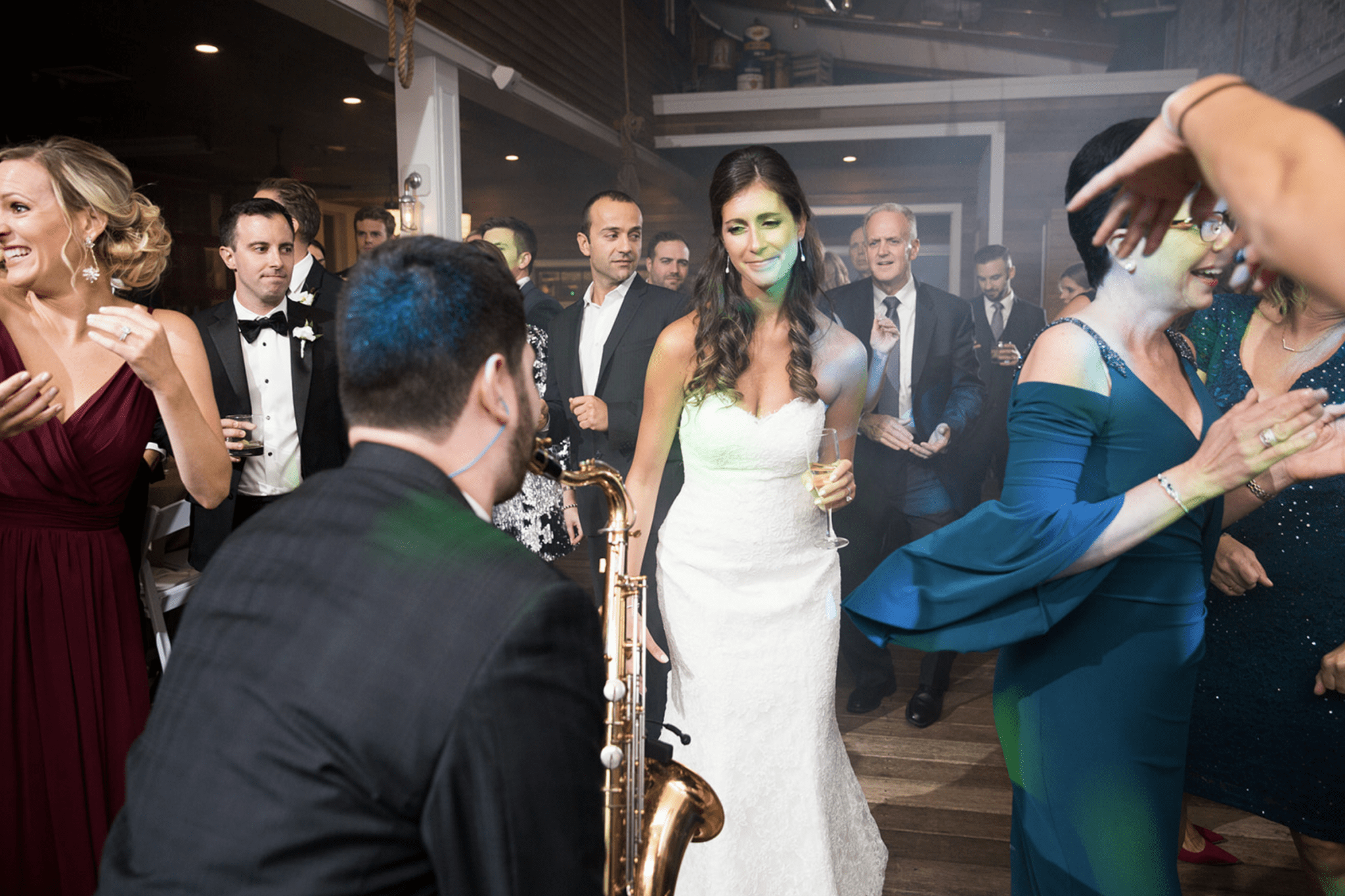 A woman in a white dress looking at a saxophone player.