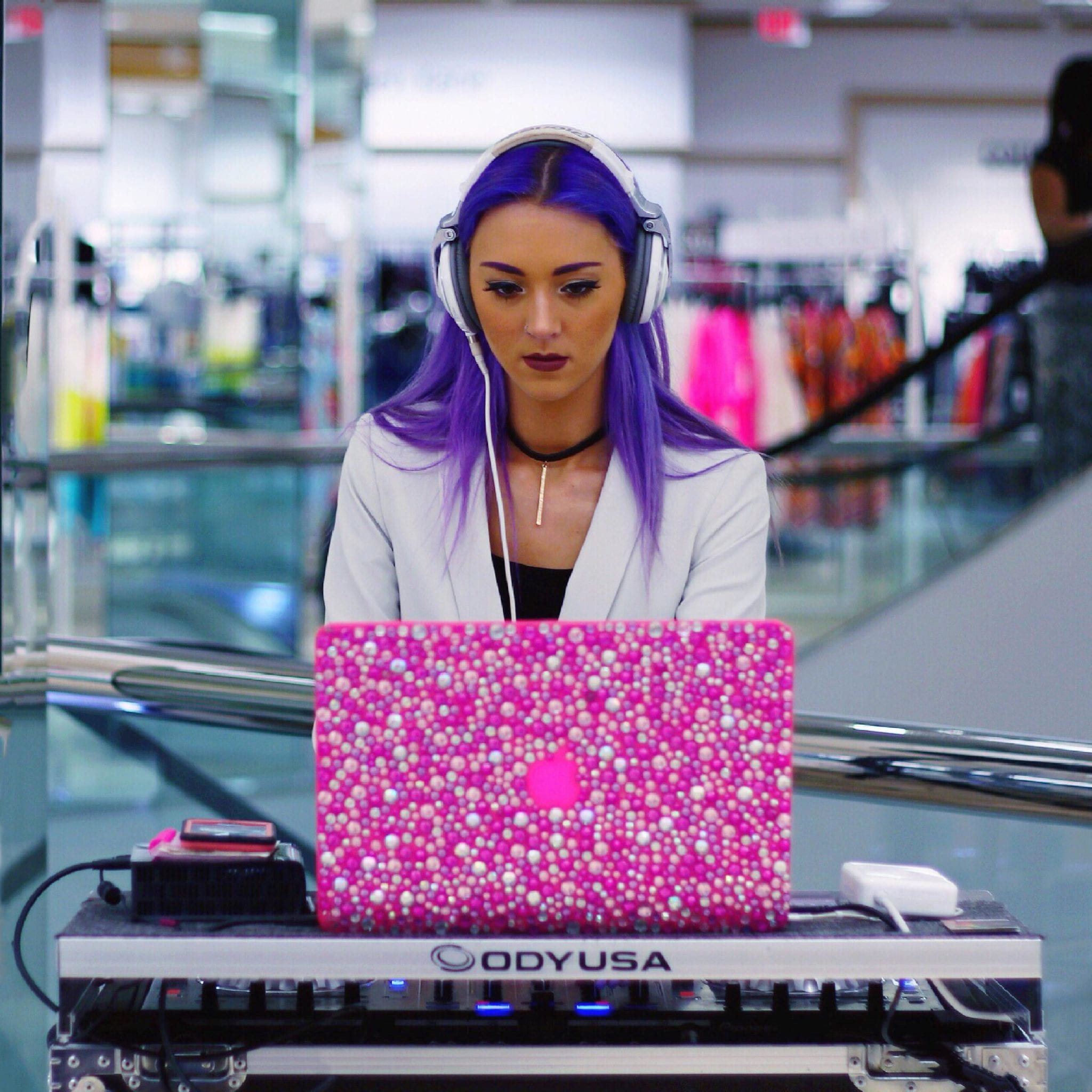 DJ Chelli at a pink laptop.